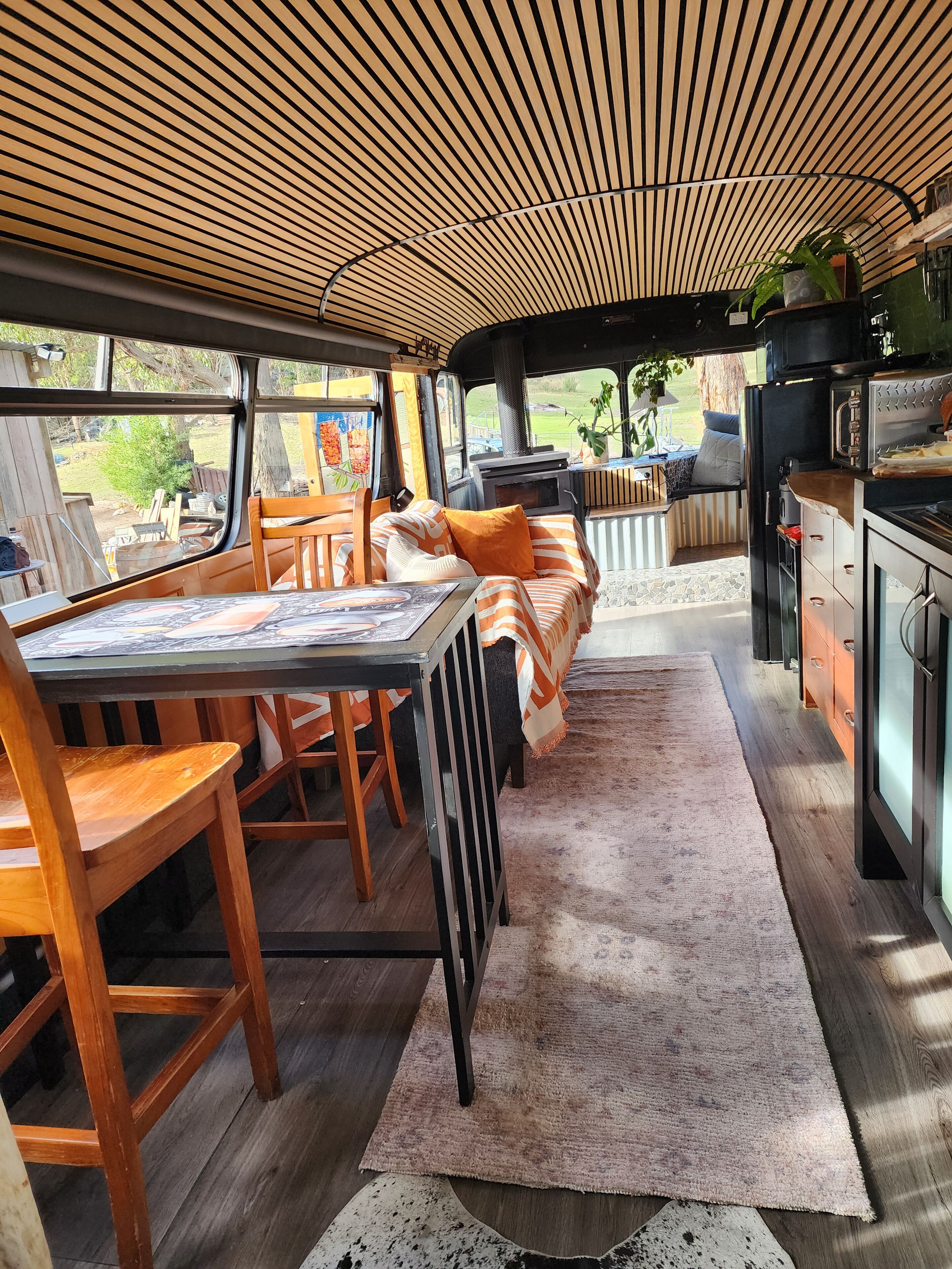 A cozy interior with a dining area, kitchen, and a view of the outdoors.