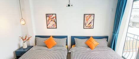 A hotel room with two beds, a projector, and artwork on the walls.