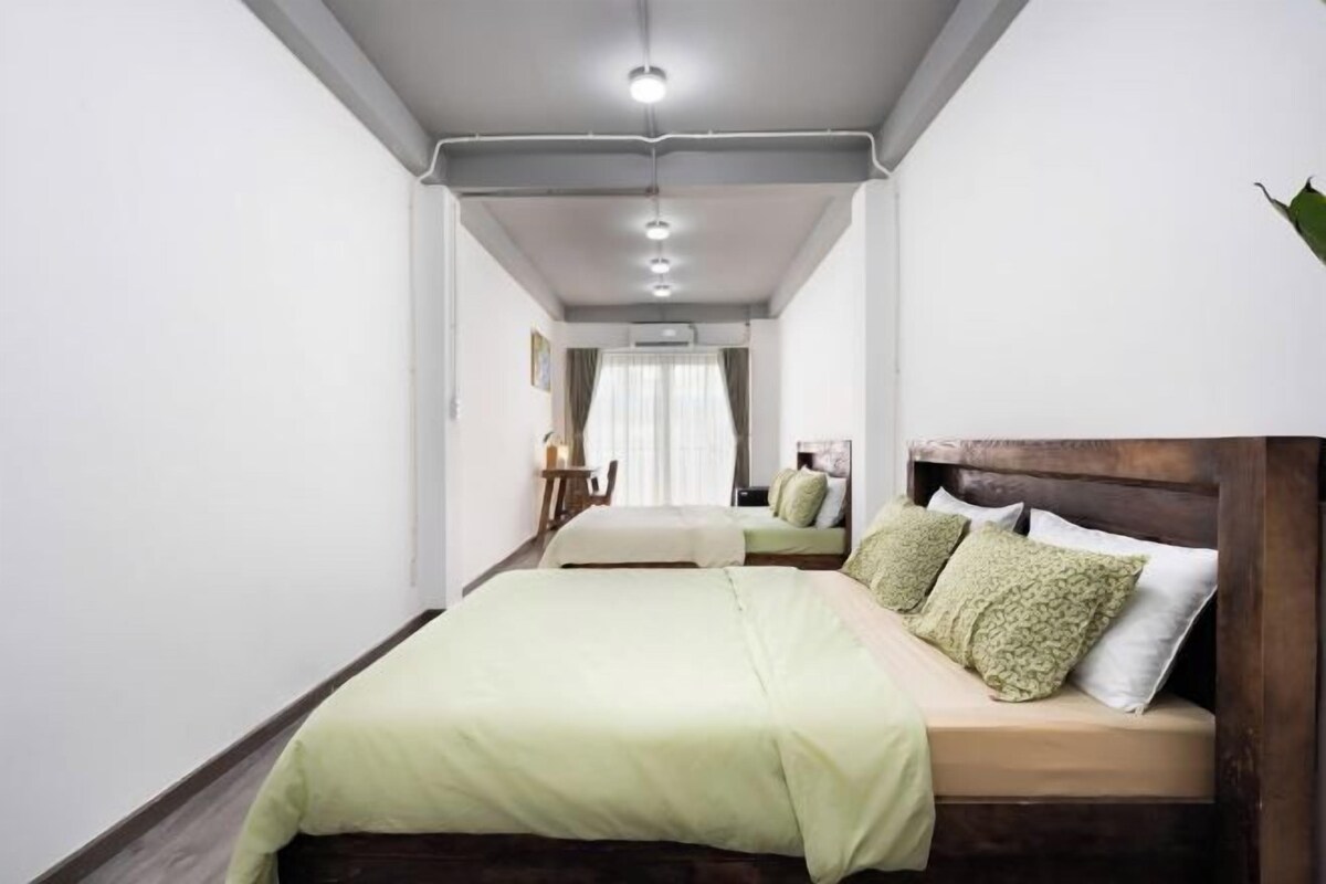 A bedroom with a large bed, a wooden headboard, and a bedside table with a lamp.