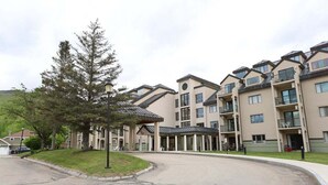 A multi-story residential building with a central courtyard, balconies, and a parking area. - Rivergreen 301, Lincoln (Lincoln)