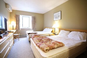 A hotel room with a bed, a desk with a chair, a television, and a window with curtains. - Rivergreen 301, Lincoln (Lincoln)