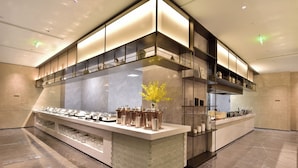 A modern kitchen with a central island, built-in shelves, and a decorative vase. - Jinling Purple Mountain Hotel Xian (Xi'an)