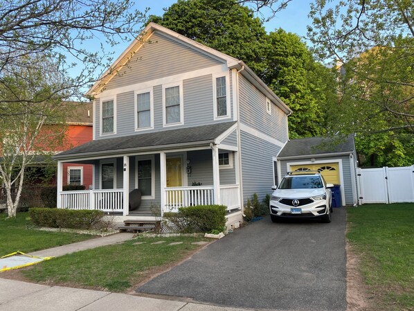 A two-story house with a front porch, garage, and a driveway.