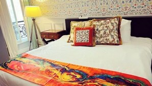 A hotel room with a bed, a nightstand, a lamp, and a window with a view. - Champs Elysees Charming (2 Bedrooms and 1 Living Room) (Paris)