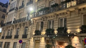 A multi-story building with ornate architectural details, including balconies with plants and wrought iron railings. - Champs Elysees Charming (2 Bedrooms and 1 Living Room) (Paris)