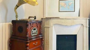 A vintage gramophone on a wooden cabinet with a world map on the wall. - Champs Elysees Charming (2 Bedrooms and 1 Living Room) (Paris)