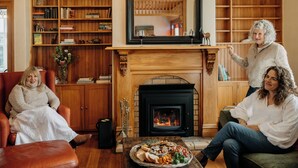Een gezellige woonkamer met een open haard, houten boekenkasten en een comfortabele zithoek.