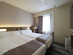Two large beds and a flat-screen TV in a spacious room with a large window and heater.