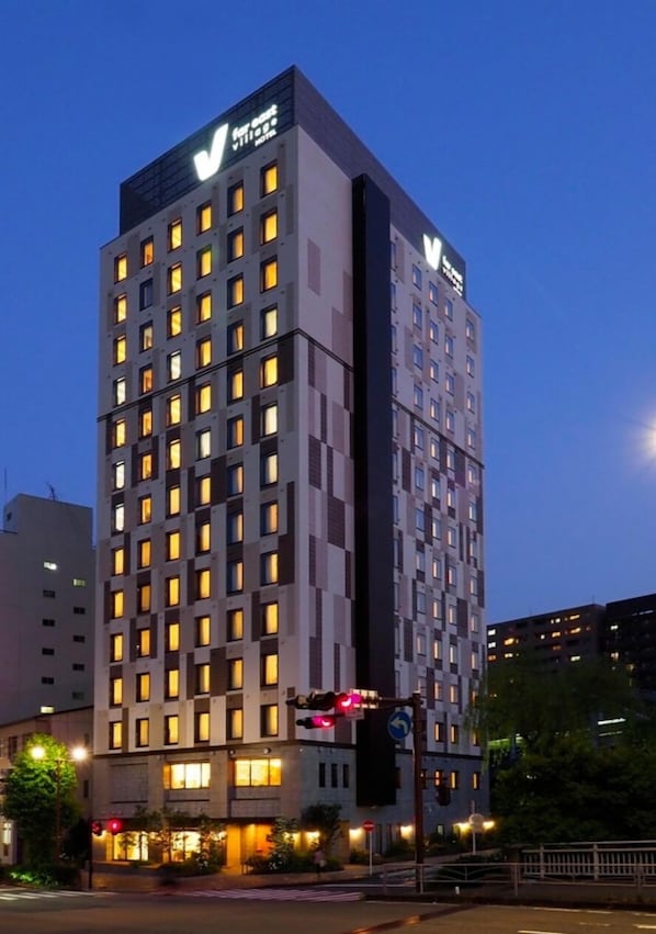 Standing tall in the city, this high-rise hotel boasts a striking 'V' logo on its facade.