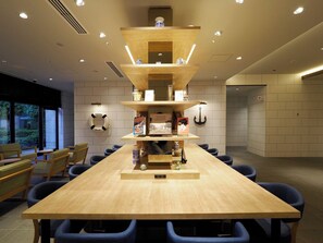Meetings take place around a long, rectangular table surrounded by blue upholstered chairs in this functional conference room.