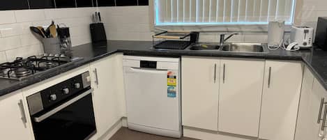 Een magnetron, een oven, een kookplaat, een vaatwasser