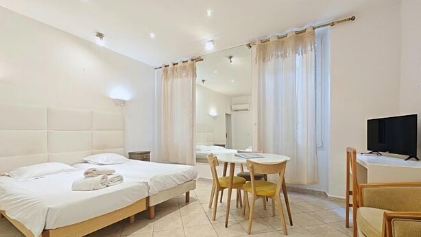 A hotel room with a bed, a desk, a chair, and a television. - Viva Riviera 11 Rue Commandant Andre (Cannes)