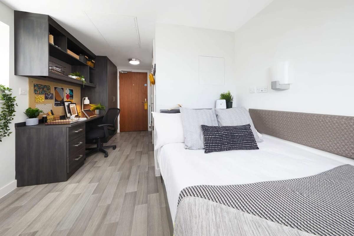 Ein modernes Schlafzimmer mit Bett, Schreibtisch und Stuhl.