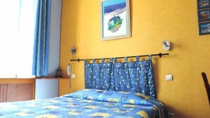 A room with a bed, a window with curtains, a wall clock, and a framed picture. - Hotel Provence by Adonis (Digne-les-Bains)