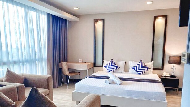 Een moderne hotelkamer met een groot bed, een bureau en een bank.