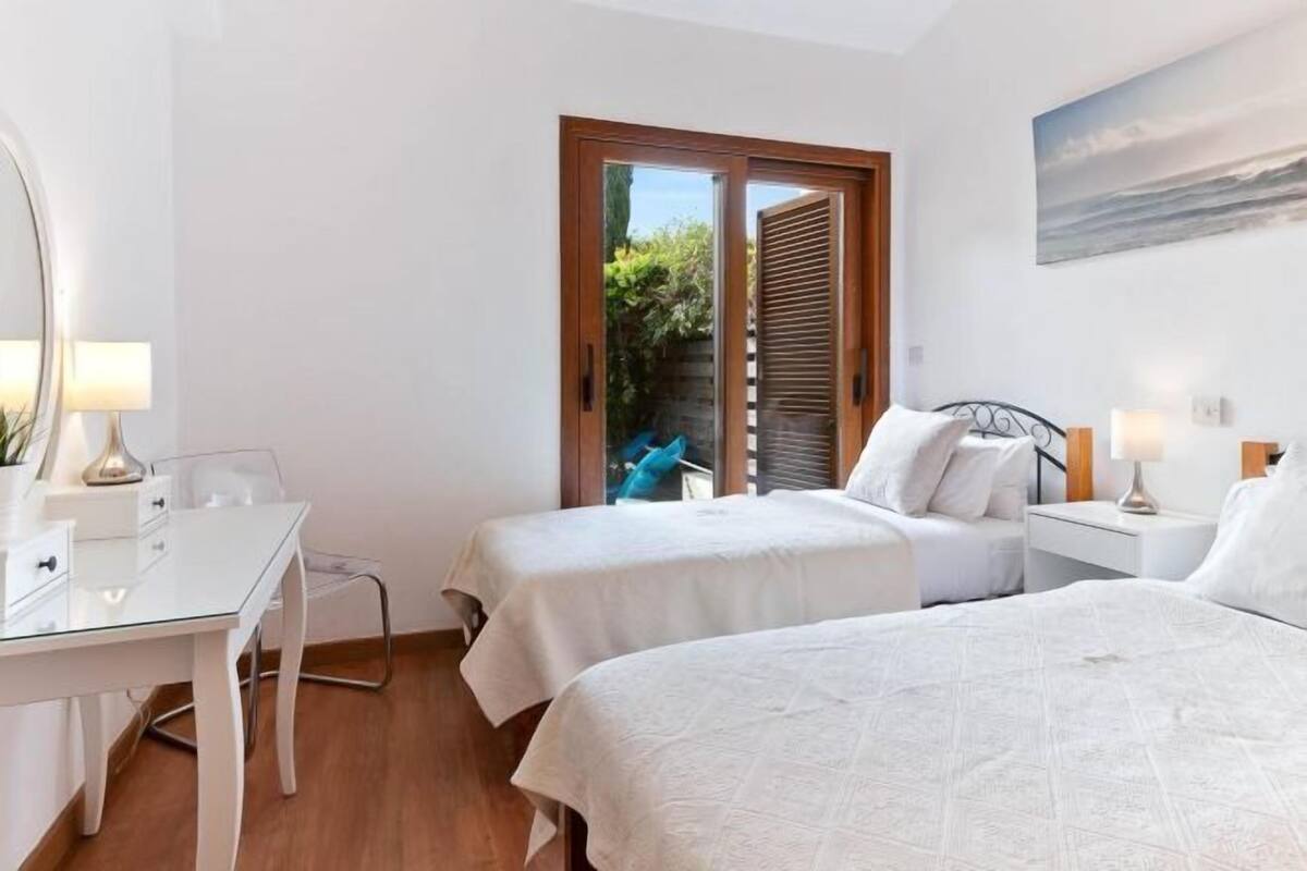 A room with two beds, a desk, and a chair.