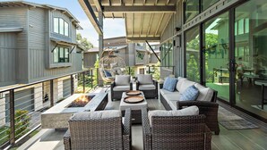 A modern outdoor patio with wicker furniture, a hanging chair, and a fire pit. - Lake Travis Getaway / Pickleball / Grill / Firepit (Lake Travis)
