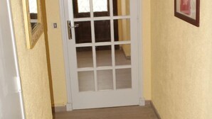 A narrow hallway with a white door and a framed picture on the wall. - Villa les Carlets (Saignon)