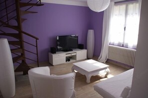 Relax in this stylish living room with a flat-screen TV, speakers, and a comfortable sofa.