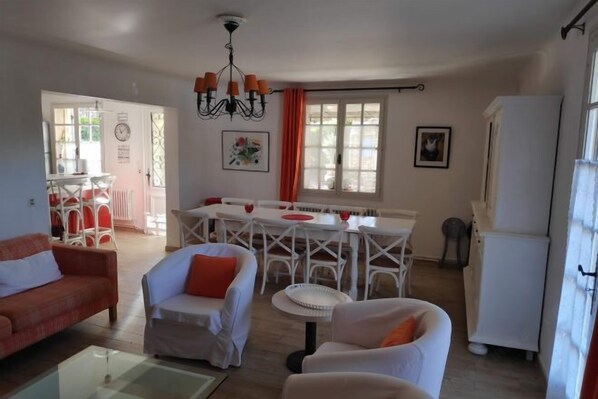 A cozy living room with a sofa, armchairs, and a dining area with a table and chairs. - Villa les Carlets (Saignon)