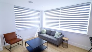 Ein modernes Wohnzimmer mit einer Couch, einem Couchtisch und einem Sessel.