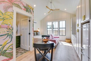 Una cucina moderna con zona pranzo, ventilatore a soffitto e un'ampia finestra.