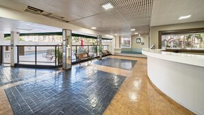 A reception area with a check-in counter, a waiting area with benches, and a tiled floor.