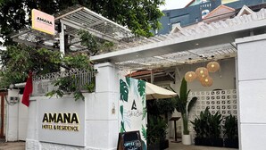 The exterior of Amana Hotel & Residence with a signboard, a cafe & bistro banner, and a coffee menu sign. - AMANA Hotel & Residence - Vo Thi Sau (Ho Chi Minh City)