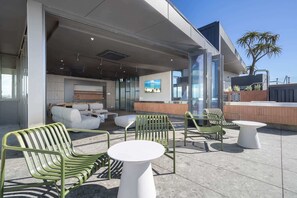 An outdoor seating area with green chairs and white tables, a reception desk, and a view of the sky. - Stylish Studio Near Fremantle Cafés and Beaches (North Fremantle)