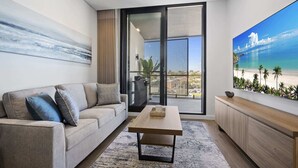 Un saló modern amb un sofà, una taula de centre i un gran finestral amb vista a una platja.