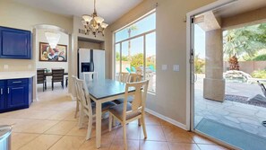 A kitchen with a dining table and chairs, a refrigerator, and a chandelier. - Sleeps 10! Heated Pool~Putt Putt~Dogs Welcome! (Chandler)