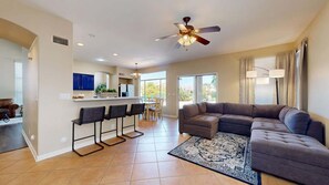 A spacious living area with a sectional sofa, a bar with stools, a dining area, and a kitchen in the background. - Sleeps 10! Heated Pool~Putt Putt~Dogs Welcome! (Chandler)