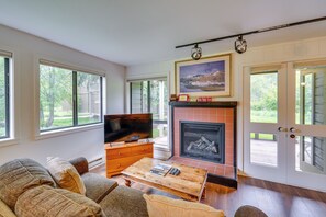 A living room with a fireplace, television, and comfortable seating.