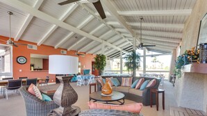 A spacious indoor area with high ceilings, wicker furniture, and a large window providing natural light. - 2 Mi to Dtwn Palm Springs: Mtn-View Condo w/ Pool (Palm Springs)