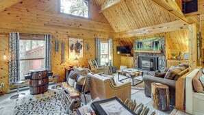 A cozy cabin interior with wooden walls, a fireplace, and a comfortable seating area. - Hot Tub + Arcade Table: Spacious Retreat in Lead (Lead)