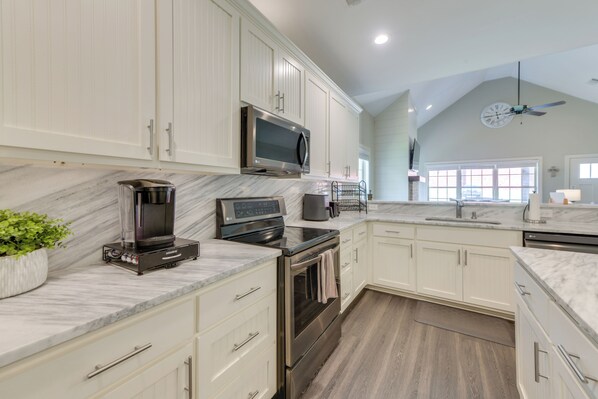 Enjoy cooking in this well-equipped kitchen with a stainless steel range, coffee maker, and ample counter space.