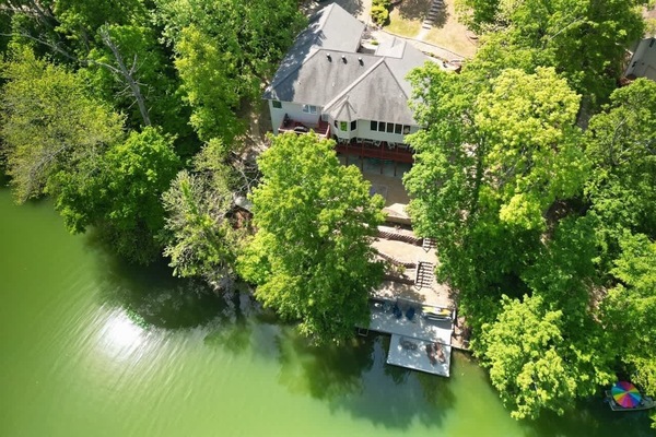 Bird’s-eye view of your private lakefront home and dock on Loch Lomond, tucked amid lush trees.