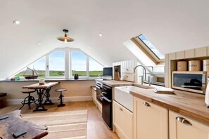 A modern kitchen with a skylight, large windows, and a view of the countryside. - Swn y Môr - 1 Bedroom Cottage - Whitesands (Saint David's and the Cathedral Close)