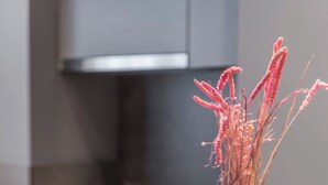 Eine Küchenarbeitsplatte mit einer Zeitschrift und einer Vase getrockneter Blumen.
