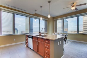 A modern kitchen with a central island, large windows, and a ceiling fan. - Incredible Views | Downtown | Free Parking (Cleveland)