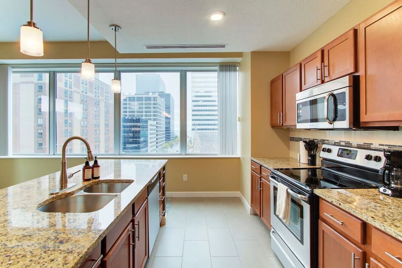 A modern kitchen with granite countertops, stainless steel appliances, and wooden cabinets.