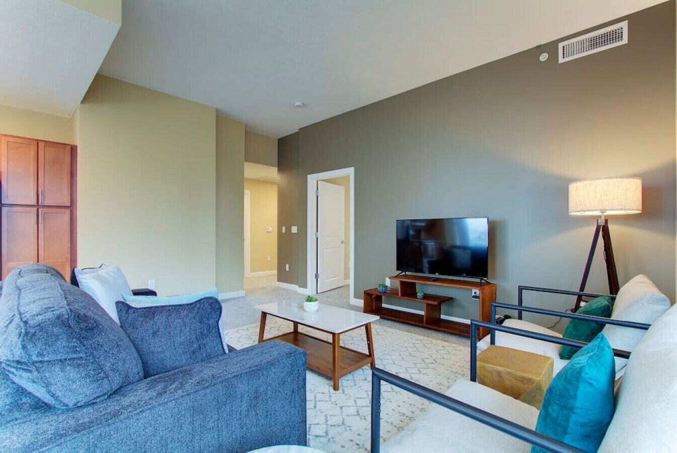 A living room with a sofa, coffee table, TV, and lamp.