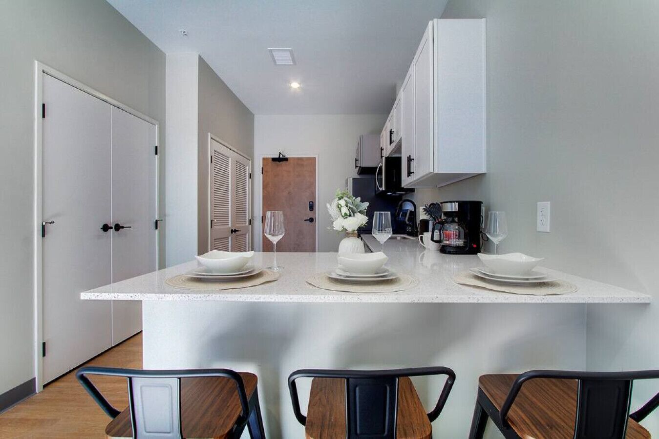 Quartz dining bar with seating for meals, coffee, or working from the apartment.