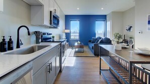 Una cocina moderna con una isla grande, electrodomésticos integrados y un comedor con vistas.