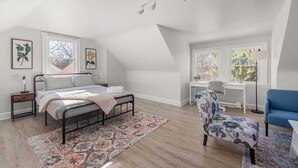 Une chambre à coucher avec un lit, un bureau, une chaise et une fenêtre.