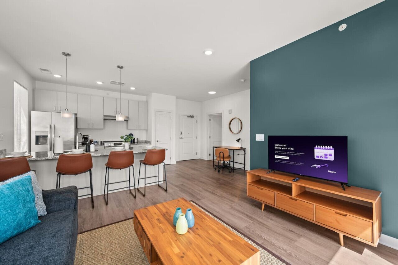 A modern living room with a TV, wooden coffee table, and a sofa.