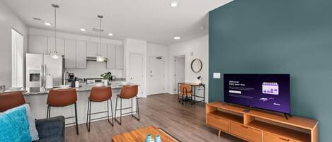 A modern living room with a TV, wooden coffee table, and a sofa.