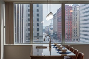 A dining area with a view of a cityscape through large windows.