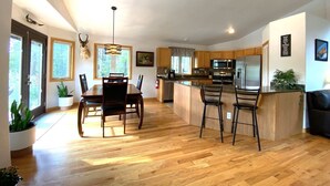 Una cocina amplia con armarios de madera, una isla central y electrodomésticos modernos.