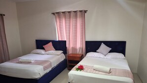 Two single beds with headboards, a nightstand, and a window with curtains. - Tavua Hotel (Tavua)